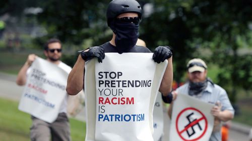 One man's sign read 'stop pretending your racism is patriotism'. (AP)