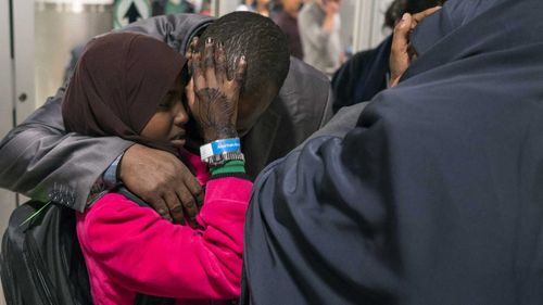 Miski Shalle, 11, embraces her father Ismail Issack as she and her sister, part of Somalian family who have been separated from their parents who have been living in the United States, reunite for the first time in seven years. (AAP)