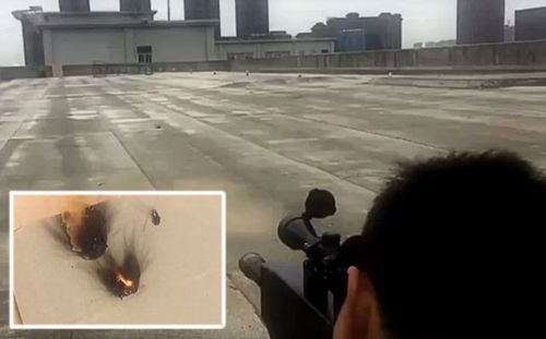 A video from the laser rifle's Chinese developers shows a test firing on a rooftop in the city of Xian.  Inset: flames from a board target hit by the laser beam.