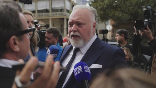 Kyle Sandilands was mobbed by reporters outside of court.