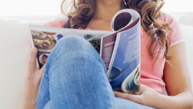 Woman relaxing on a lounge with a magazine