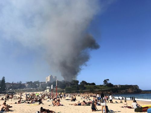 Beachgoers were billowed by smoke from the blaze at Coogee this afternoon. (AAP)