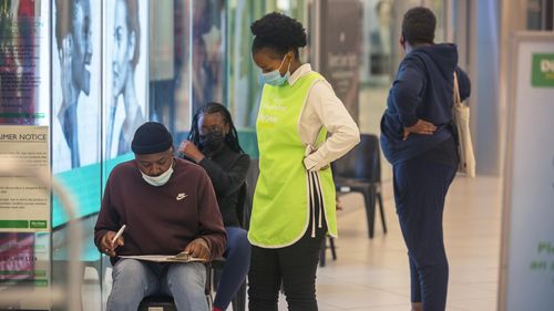 People lineup to get vaccinated at a shopping mall in Johannesburg, South Africa, Friday Nov. 26, 2021.