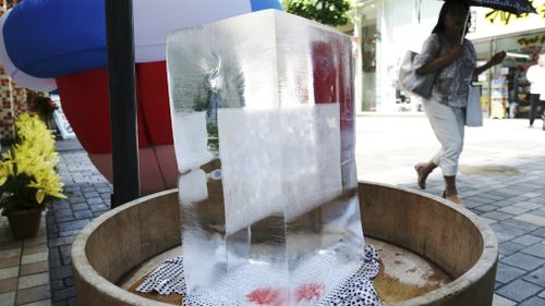 A block of ice is placed at a pedestrian street to cool down the spot in Tokyo. Picture: AAP