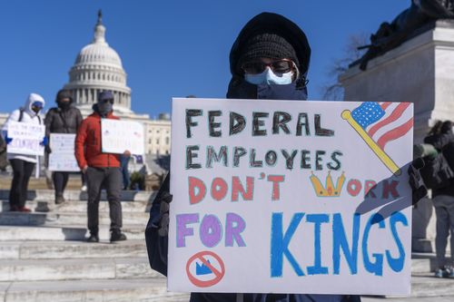 FILE - A federal employee, who asked not to use their name for fears over losing their job, protests with a sign saying "Federal Employees Don't Work for Kings" during the "No Kings Day" protest on Presidents Day in Washington, in support of federal workers and against recent actions by President Donald Trump and Elon Musk, Feb. 17, 2025, by the Capitol in Washington. (AP Photo/Jacquelyn Martin, File)