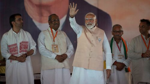 Indian Prime Minister Narendra Modi waves to the crowd as he arrives at an election campaign rally in Meerut, India.