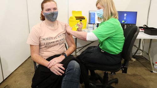 Whitney McIntosh, 27, receiving the Pfizer vaccination from registered nurse Ellen Merkason on the opening day of the COVID-19 vaccination hub at Brisbane Convention and Exhibition Centre.