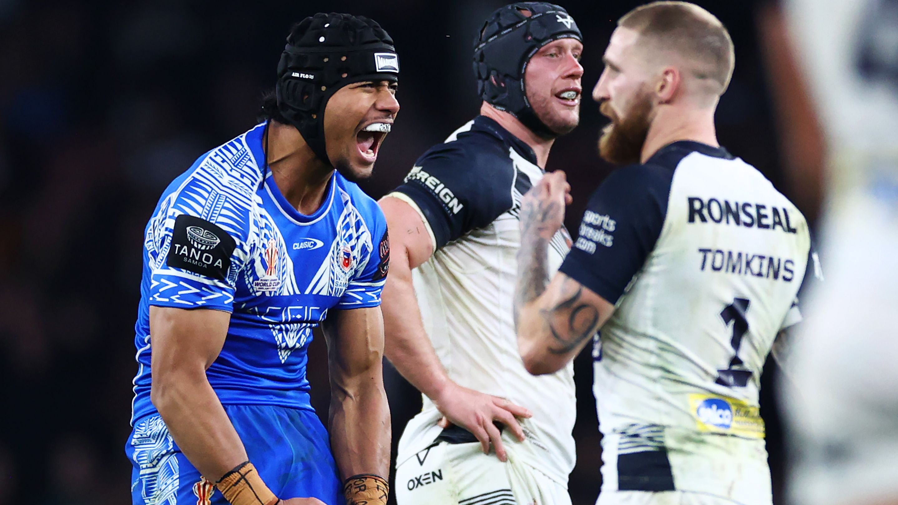 Stephen Crichton of Samoa celebrates after kicking a dropped goal, leading to Samoa winning the game as Sam Tomkins of England looks dejected  during the Rugby League World Cup Semi-Final match between  England and Samoa at Emirates Stadium on November 12, 2022 in London, England. (Photo by Michael Steele/Getty Images)