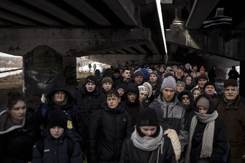 Des Ukrainiens se pressent sous un pont détruit alors qu'ils tentent de fuir en traversant la rivière Irpin dans la périphérie de Kiev, en Ukraine, le mardi 8 mars 2022.