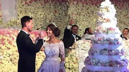 A tiny glimpse of the lavish wedding ceremony, with the wall of flowers and 10-tier wedding cake in sight. (Facebook)