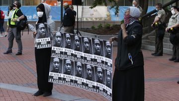 Protesters hold photos of George Floyd during a protest at the Hennepin County Government Centre in Minneapolis.
