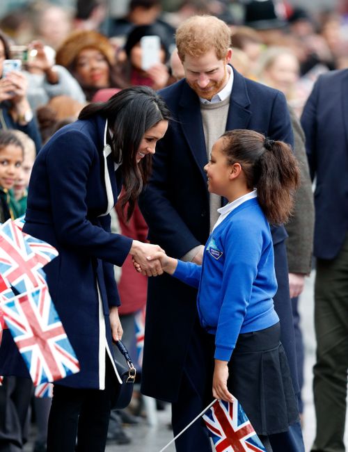 Photos of the encounter show Markle shaking the girl's hand then embracing her. Picture: Getty