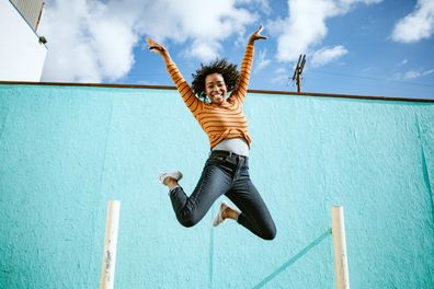 Woman smiles while jumping