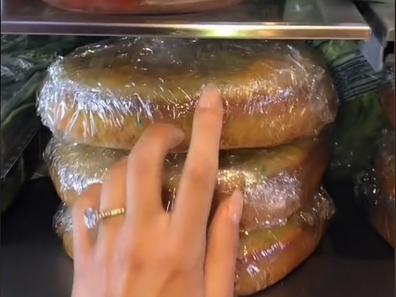 Laura Saxe showing her followers the stacked cakes in her fridge ready for icing and assembling.