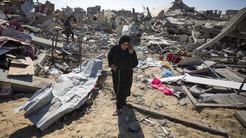 Manual Aslim walks through the rubble of her destroyed home, in Rafah, southern Gaza Strip, Tuesday, Jan. 21, 2025, days after the ceasefire deal between Israel and Hamas came into effect. (AP Photo/Abdel Kareem Hana)