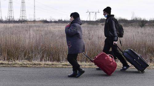 People flee from Ukraine at the Hungarian-Ukrainian border, in Lonya, Hungary.