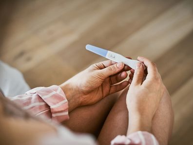 Woman holding a pregnancy test.