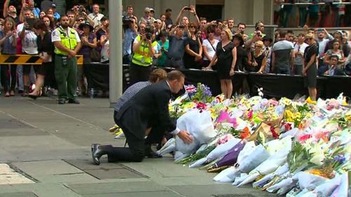 Prime Minister Tony Abbott and his wife Maggie Abbott arrive to pay their respects at the floral memorial in Martin Place. (9News)