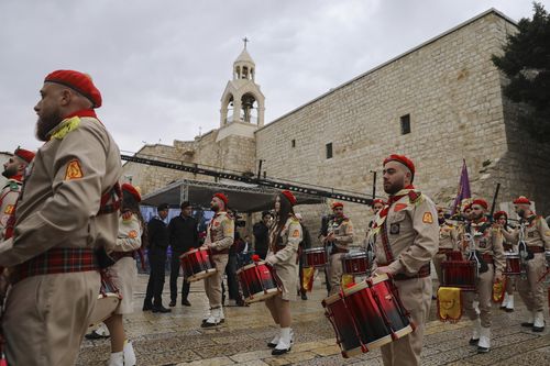 Palestinian scout bands parade through Manger Square at the Church of the Nativity,  traditionally believed to be the birthplace of Jesus Christ, during Christmas celebrations, in the West Bank city of Bethlehem, Friday, Dec. 24, 2021.