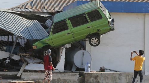 The force of the tsunami in Indonesia slammed cars into buildings.