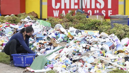 Staff work to clean up flood damage at a Chemist Warehouse at Windsor in Brisbane.