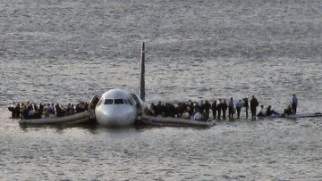 Passengers wait to be rescued on the wings of a US Airways plane that safely landed on the Hudson River in New York on January 15, 2009. 