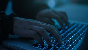 A person types on a laptop keyboard