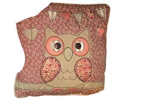 A patterned cushion with an owl displayed on it.