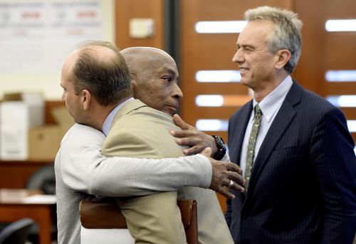 Dewayne Johnson, center, hugs one of his attorneys, next to lawyer and member of his legal team Robert F Kennedy Jr., right, after the verdict was read in his case against Monsanto at the Superior Court of California in San Francisco