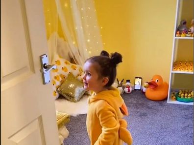 Toddler walking into her new duck-themed bedroom.