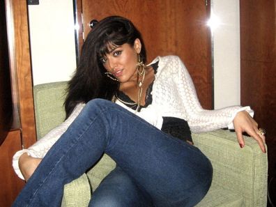 Mona Kattan poses in jeans and a long shirt at age 21.