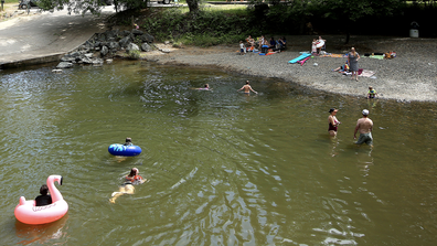 People take a dip in Squirrel Creek at Western Gateway Park in Penn Valley, Calif., Tuesday afternoon, May 26, 2020, as temperatures climbed to the mid-90s. (Elias Funez/The Union via AP)