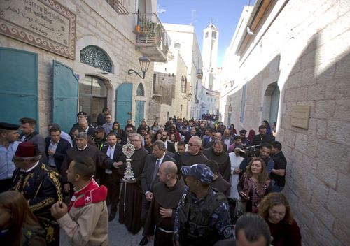 Christian clergymen carry a wooden relic believed to be from Jesus' manger outside the Church of the Nativity, traditionally believed by Christians to be the birthplace of Jesus Christ in the West Bank city of Bethlehem. A tiny wooden relic believed to have been part of Jesus' manger has returned to its permanent home in the biblical city of Bethlehem 1,400 years after it was sent to Rome as a gift to the pope.