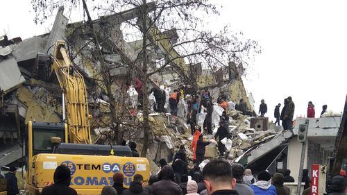 Rescue workers try to reach trapped residents in a collapsed building in Kahta, in Adiyaman province, southeastern Turkey, Monday, Feb. 6, 2023. 