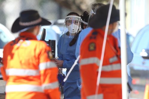 BRISBANE, AUSTRALIA - AUGUST 04: Health workers are seen at a testing clinic in Indooroopilly State High school on August 04, 2021 in Brisbane, Australia. Queensland is experiencing its biggest outbreak of the Covid-19 virus in a year with the southeast of the state under lockdown as it attempts to bring the delta variant under control. (Photo by Jono Searle/Getty Images)