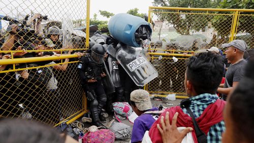 More than a hundred Central American migrants have forced their way through a customs gate at the Guatemalan border town of Tecun Uman to request passage into Mexico.