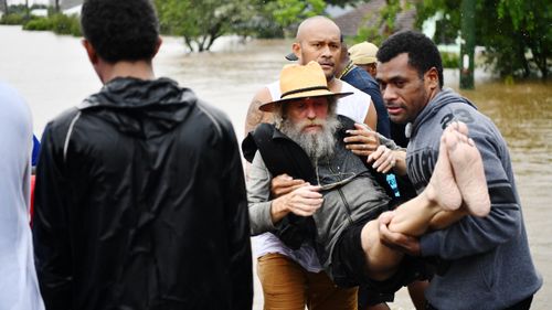 A man is carried to safety in Lismore, NSW.