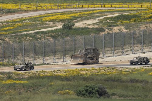 An Israeli army bulldozer is seen near the Gaza Strip border, in southern Israel, Thursday, March 21, 2024 