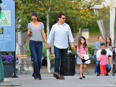 Tom Cruise, Katie Holmes and Suri Cruise walk together on October 8, 2011.