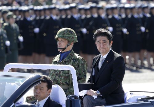 Japanese Prime Minister Shinzo Abe, right, reviews members of Japan Self-Defense Forces (SDF) during the Self-Defense Forces Day at Asaka Base, north of Tokyo on Oct. 27, 2013. 