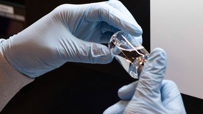 In this March 2020 photo provided by Gilead Sciences, a vial of the investigational drug remdesivir is visually inspected at a Gilead manufacturing site in the United States. Given through an IV, the medication is designed to interfere with an enzyme that reproduces viral genetic material. (Gilead Sciences via AP)