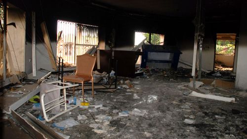 Glass, debris and overturned furniture are strewn inside a room in the gutted U.S. consulate. (AAP)