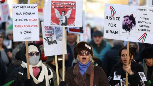Demonstrators hold placards during an Iranian anti-government protest on December 10, 2022 in London, England. 