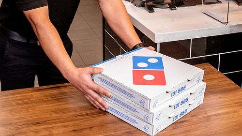 Domino's staff wearing face mask in store, picking up pizza