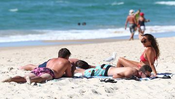 People relax on the beach at Burleigh Heads on the Gold Coast.