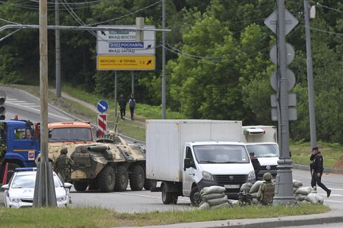 Russian army servicemen, and police officers guard the highway at the entrance to Moscow, Russia, Saturday, June 24, 2023. 
