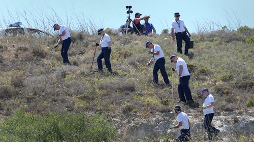 British police officers search an area of wasteland in 2014 during a search for evidence of Madeleine McCann in the town of Praia da Luz, Portugal where she went missing in May 2007.