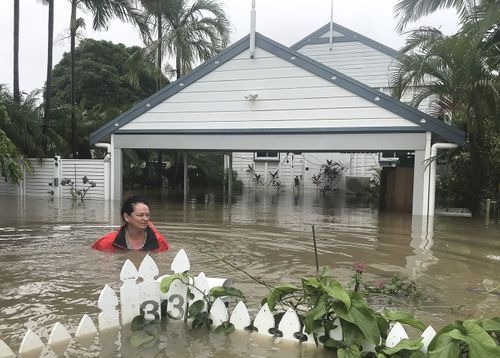 Townsville resident Amelia Rankin almost up to her shoulders in floodwaters at her home.