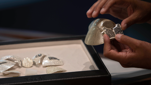 Isaac Levy, owner of Israeli jewelry company Yvel holds parts of a mask in Motza near Jerusalem, Sunday, Aug. 9, 2020.   (AP Photo/Sebastian Scheiner)