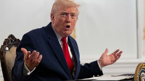 O presidente Donald Trump fala aos repórteres depois de falar com as tropas por vídeo de sua propriedade em Mar-a-Lago no Dia de Ação de Graças.